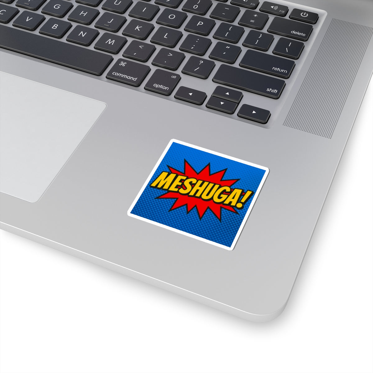 Laptop with a 'MESHUGA!' sticker on the palm rest area