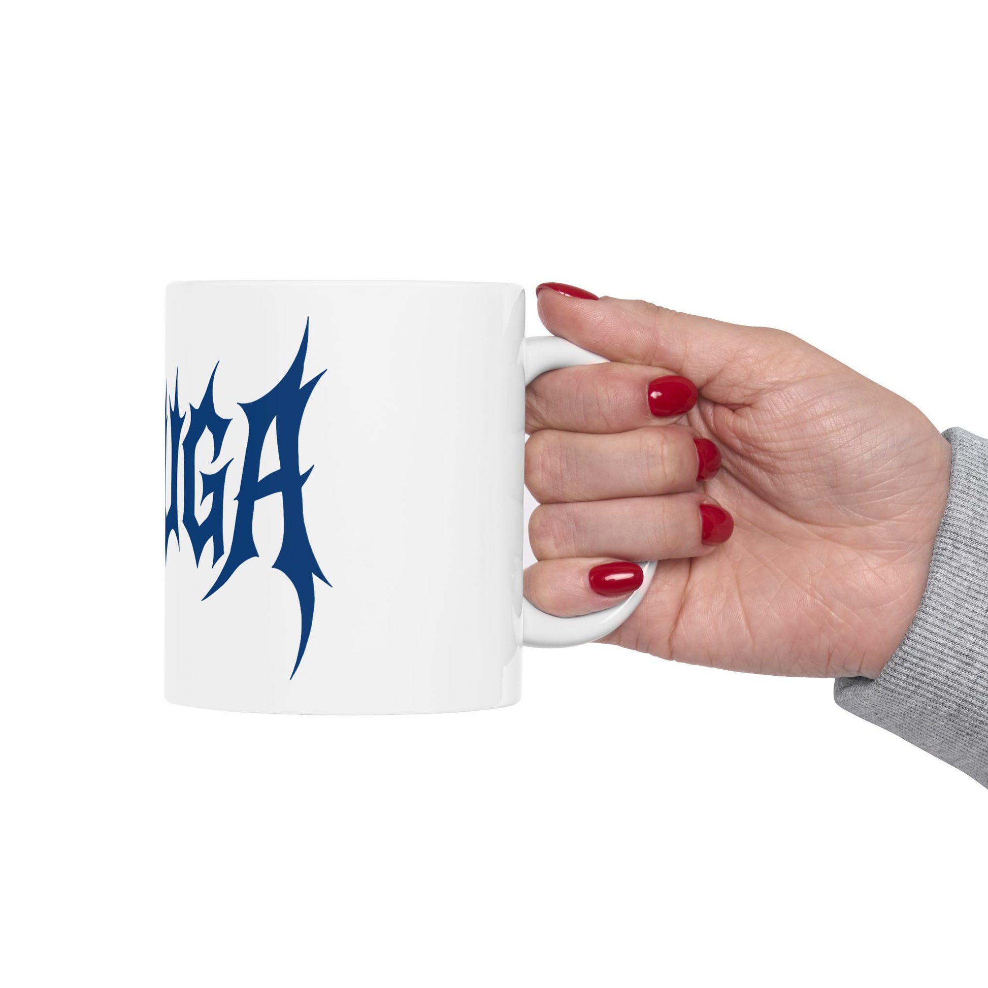 Hand holding a white mug with 'meshuga' in blue text on a white background