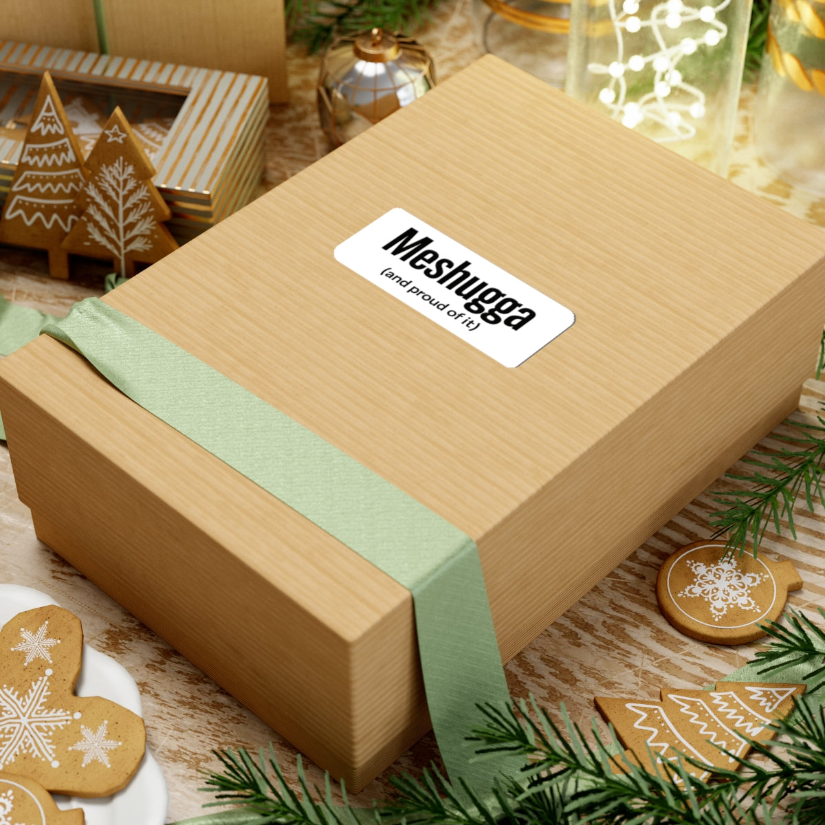 Wooden gift box with a green ribbon and 'Meshugga' label on a festive background with cookies and lights.