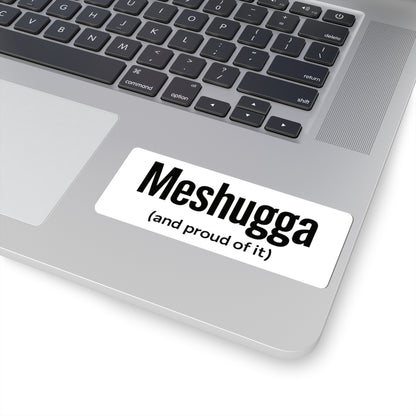 Laptop with a sticker reading 'Meshugga (and proud of it)' on a white background