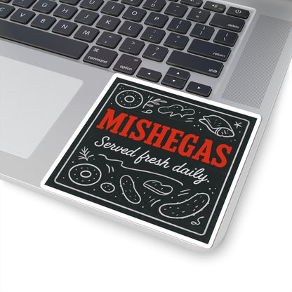 Sticker with 'MISHEGAS Served fresh daily' text on a laptop