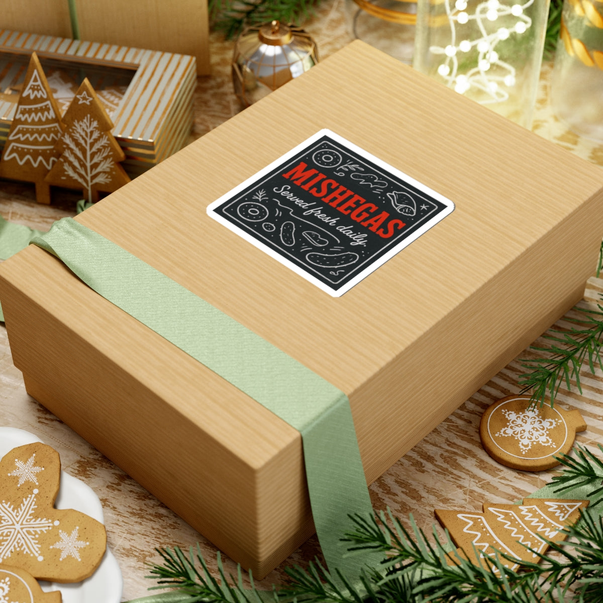 Wooden gift box with a green ribbon and 'Mishegas' label on a festive background with cookies and lights.