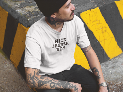 Person wearing a white t-shirt with 'Nice Jewish Boy' text, sitting on a yellow and black striped curb.