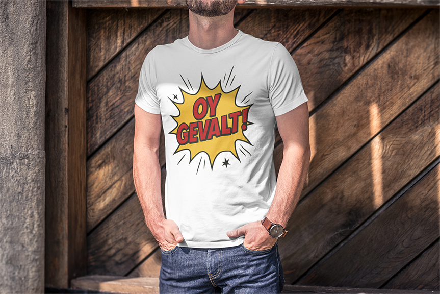 Person wearing a white t-shirt with 'Oy Gevalt!' design against a wooden background