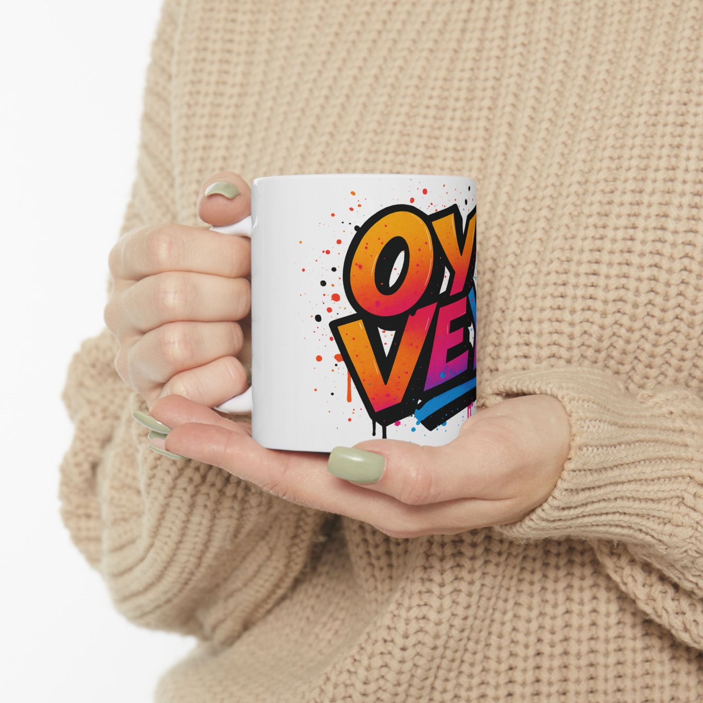 Person holding a mug with colorful 'oy vey' design against a neutral background