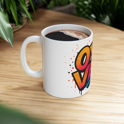 White mug with colorful 'oy vey' design on a wooden table