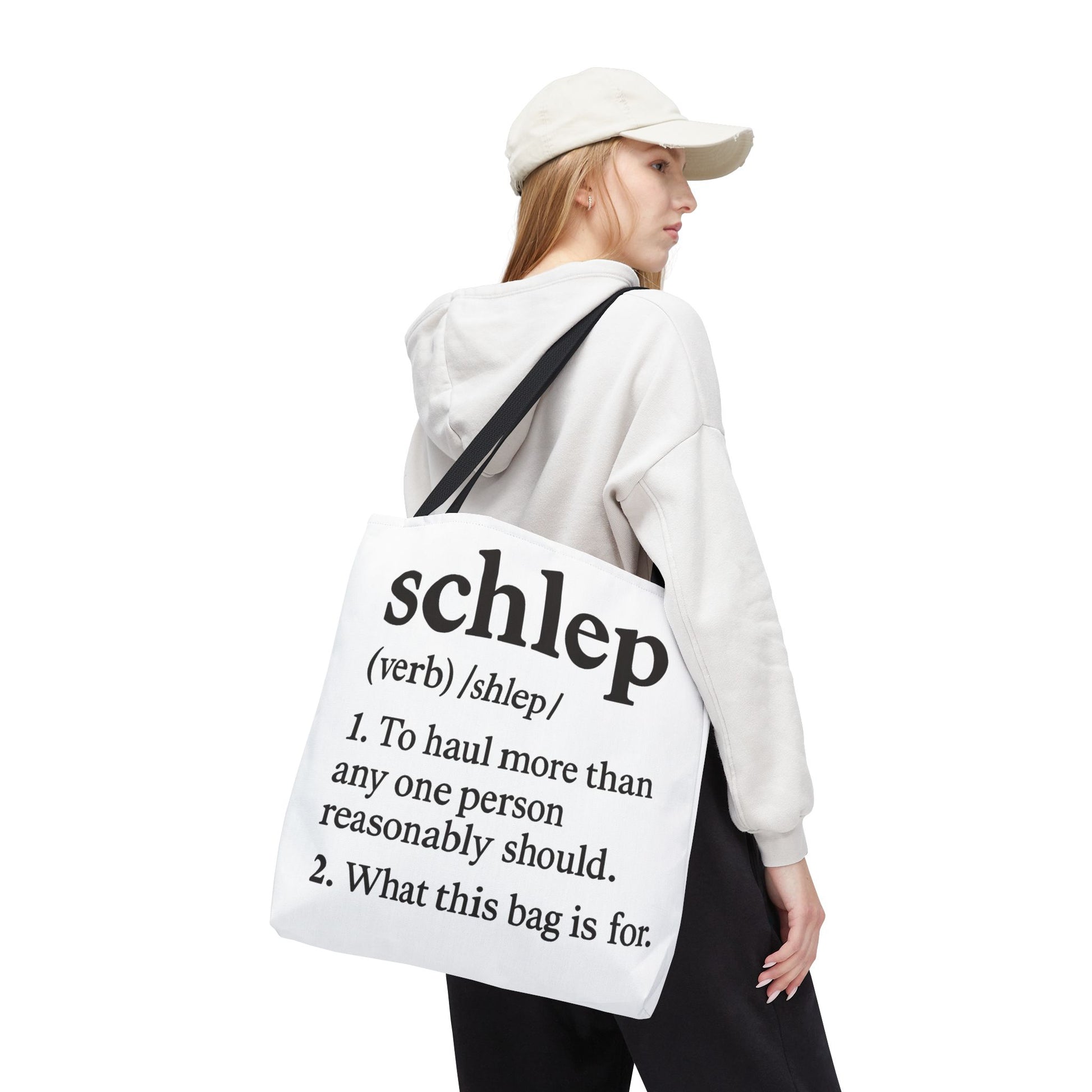 Person wearing a white hoodie and cap, carrying a tote bag with text on a white background