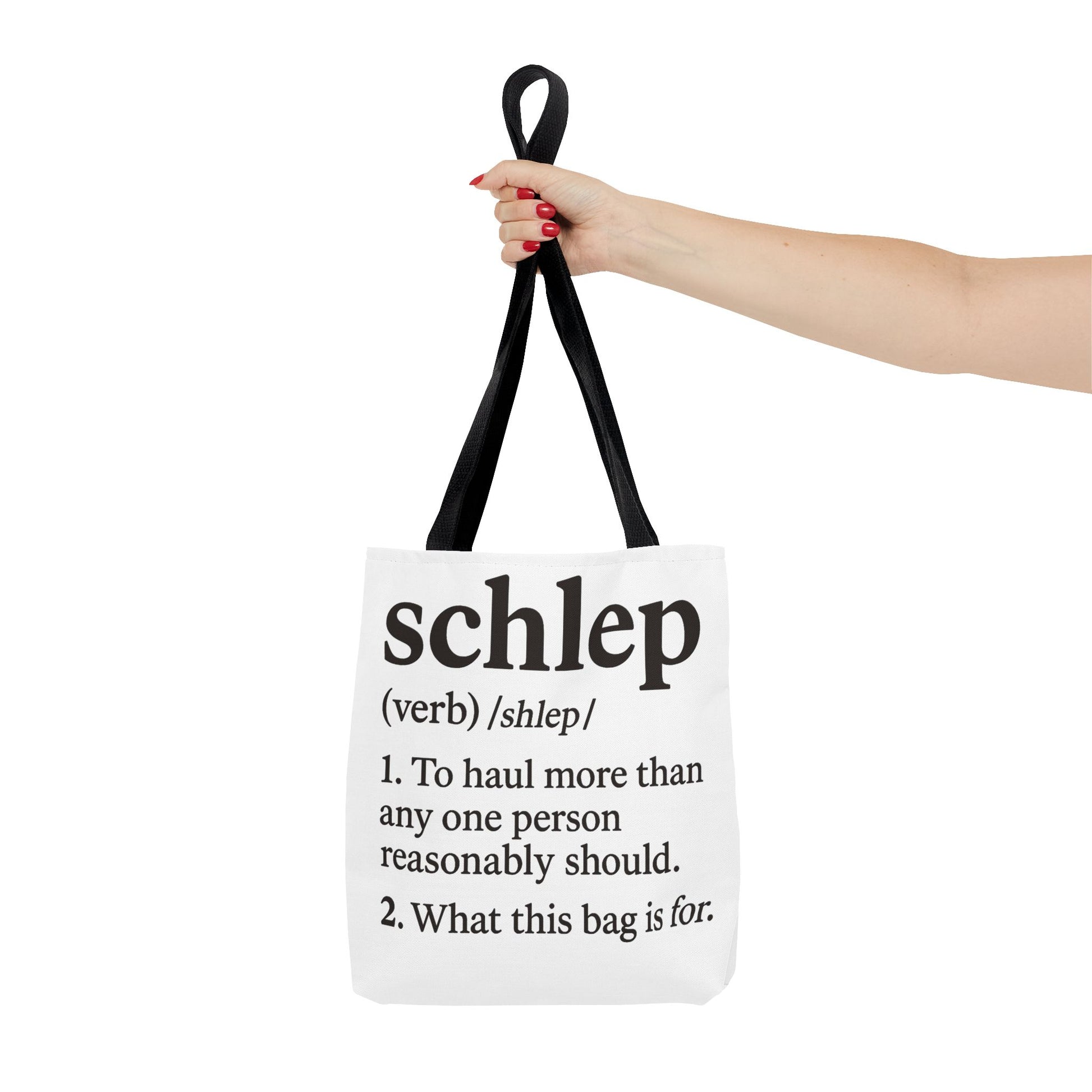 Tote bag with definition of 'schlep' held by a hand on a white background