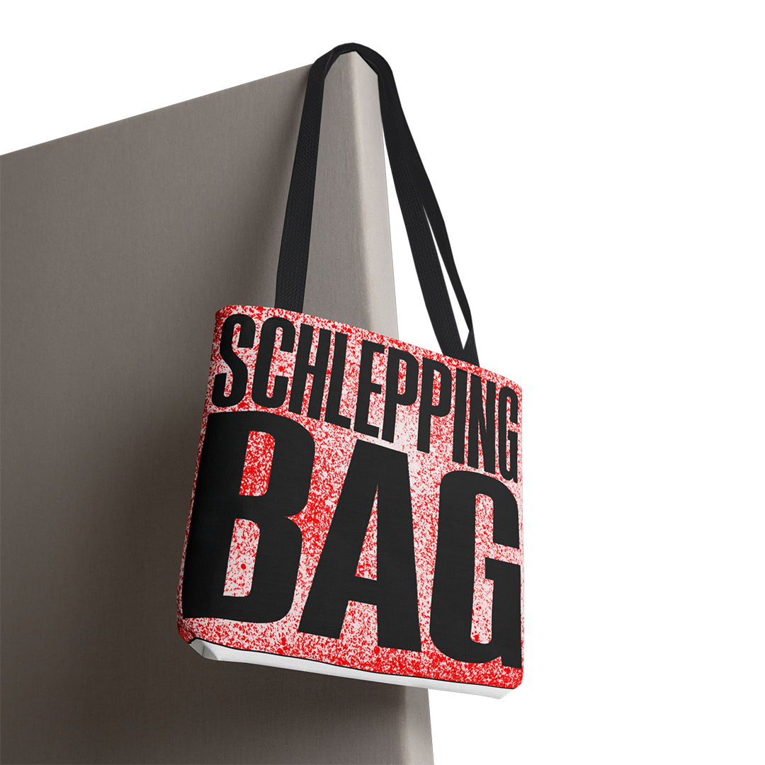 Tote bag with 'SCHLEPPING BAG' text on a gray background