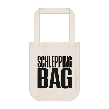 Beige tote bag with black text 'SCHLEPPING BAG' on a white background