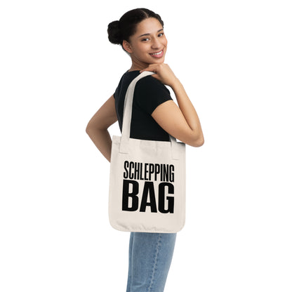 Woman carrying a tote bag with 'SCHLEPPING BAG' text on a white background