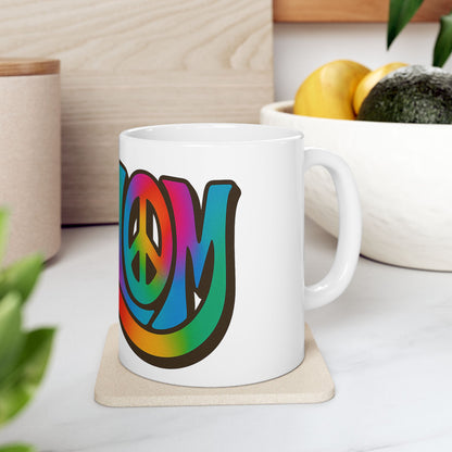 White mug with colorful 'shalom' design on a white surface with plants and a bowl in the background