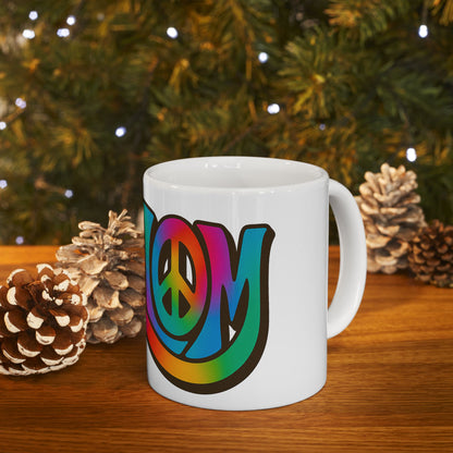 White mug with rainbow 'shalom' design on a wooden surface with Christmas decorations.