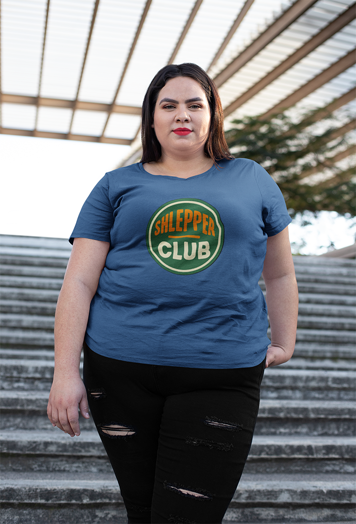 Person wearing a blue t-shirt with 'Shlepper Club' design on steps outdoors