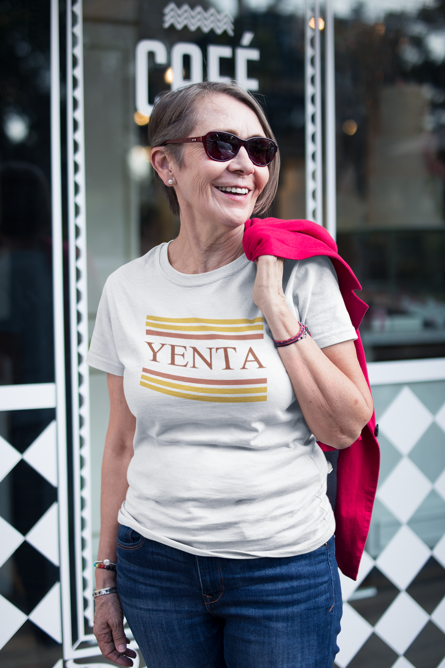 Woman wearing a 'YENTA' t-shirt in front of a coffee shop.