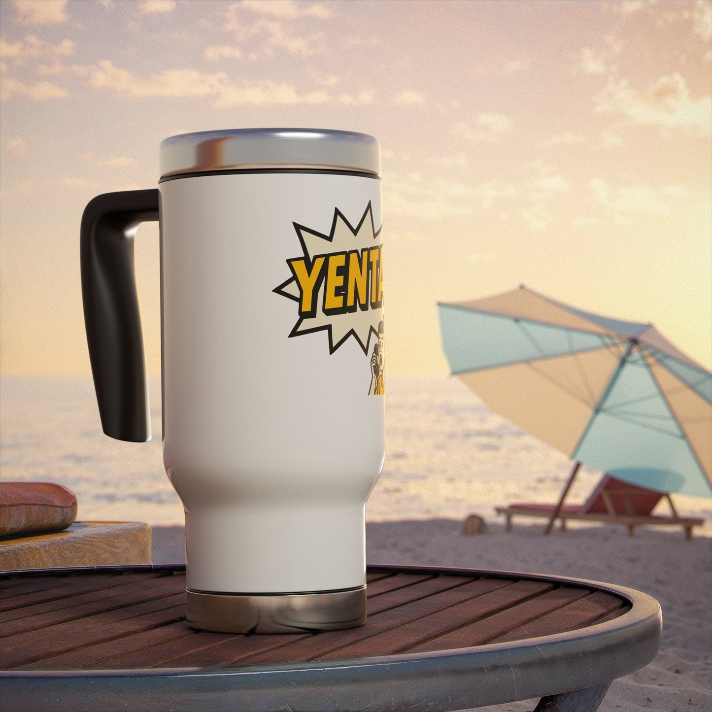 White travel mug with 'Yenta' logo on a beach table with an umbrella and sand in the background