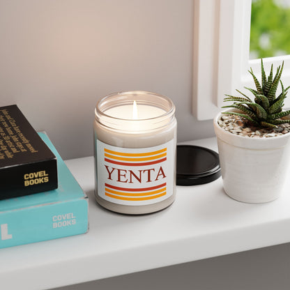 Yenta candle on a shelf with books and a plant