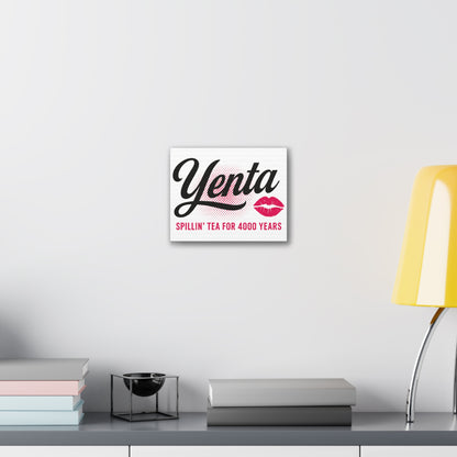 Decorative sign with 'Yenta' text on a wall above a desk with books and a lamp.