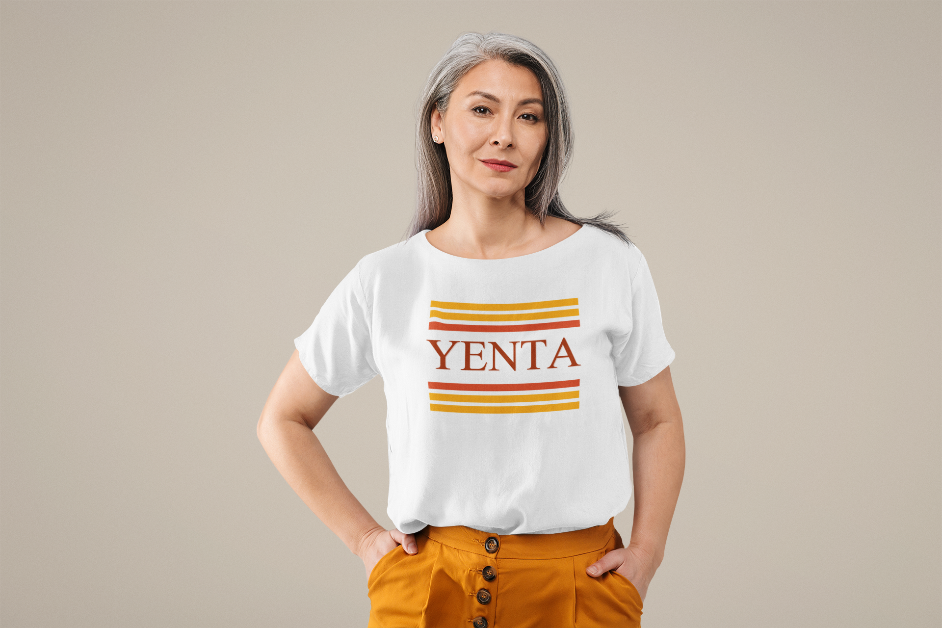 Woman wearing a white t-shirt with 'YENTA' printed on it against a beige background
